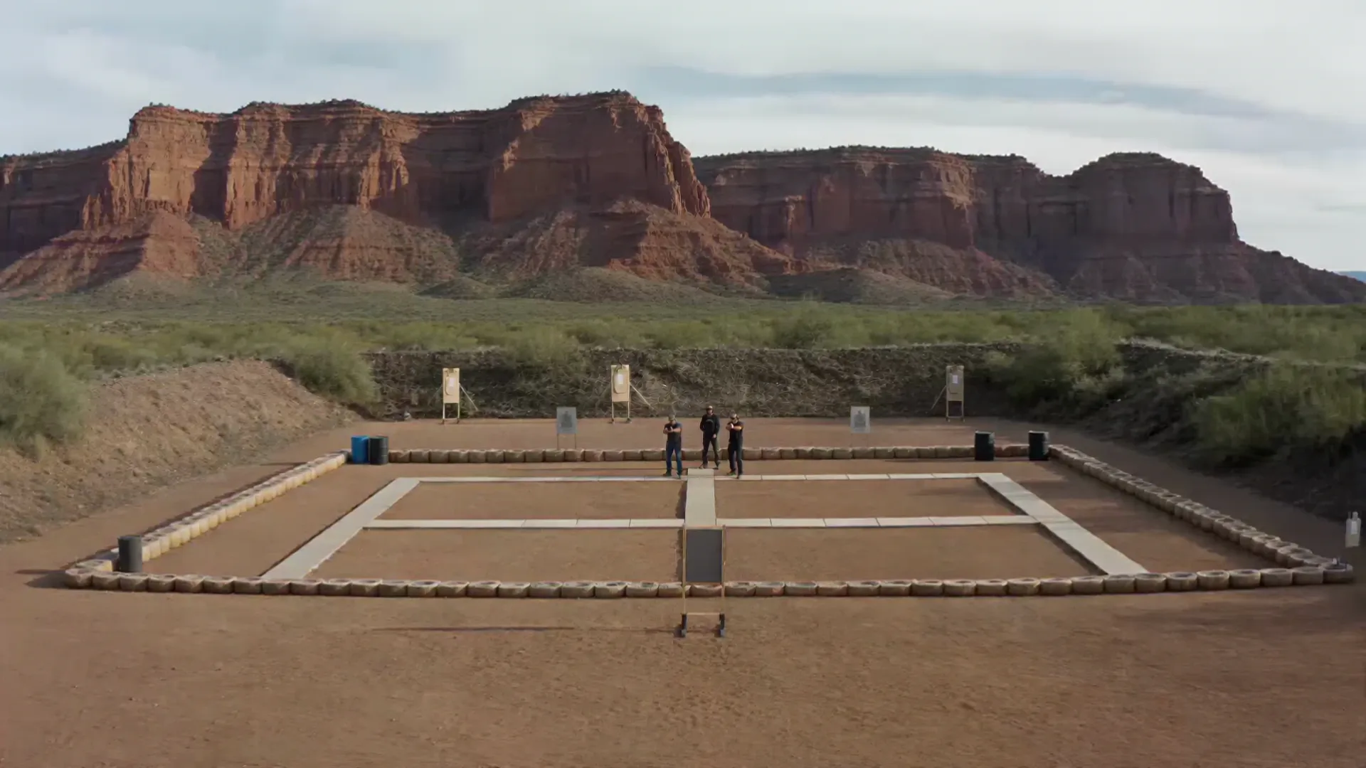 Cinematic firearms training range beneath red rock cliffs